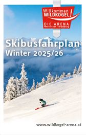 Ein Skifahrer fährt die verschneite Piste hinunter, umgeben von schneebedeckten Bäumen und einem klaren Himmel. Der Hintergrund zeigt beeindruckende Berggipfel.