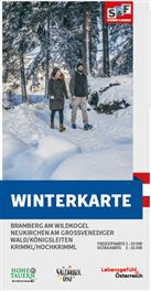 Eine Winterlandschaft mit schneebedeckten Wegen und hohen Bäumen. Im Hintergrund sind Personen, die durch die Winterlandschaft spazieren.