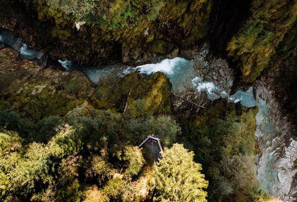 Een adembenemend landschap met dicht groen en een heldere rivier. Het uitzicht van boven laat de schoonheid van de natuur en de verborgen hut zien.