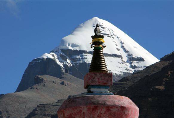 Ein bewundernswerter Berg mit schneebedecktem Gipfel ist im Hintergrund zu sehen. Im Vordergrund steht eine bunte Stupa.
