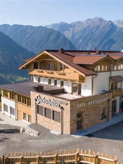 Een gezellig restaurant in de bergen met een pittoresk uitzicht. De omgeving is groen en het berglandschap is indrukwekkend.