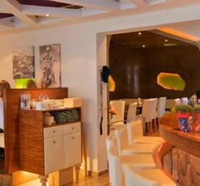 Een modern café met een uitnodigende sfeer. Gasten zitten aan tafels en genieten van hun tijd samen.