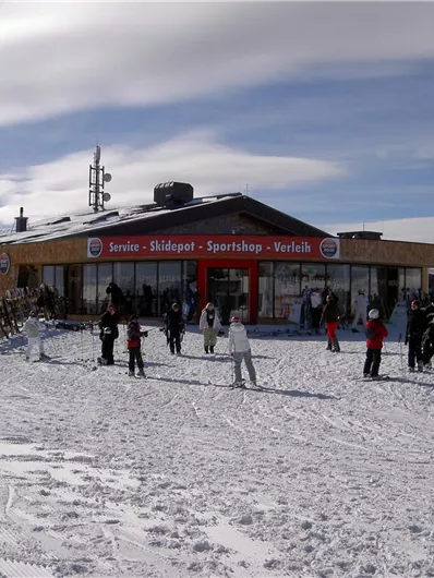 Ein modernes Ski-Hüttenrestaurant in den Bergen. Viele Menschen genießen die Winterlandschaft und die schneebedeckte Umgebung.