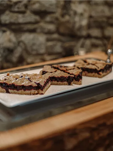 Three pieces of cake on an elegant plate. The stone wall in the background gives the presentation a rustic charm.