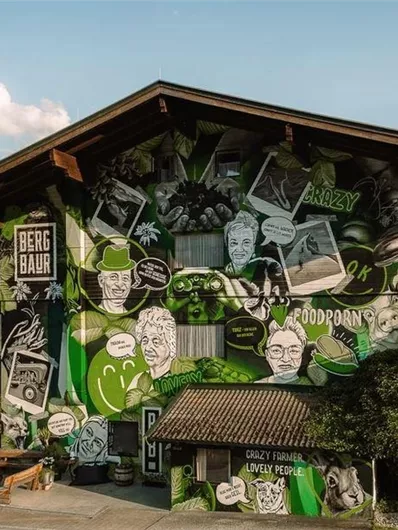 A colorfully designed house with artistic murals. The drawings depict various characters and texts in vibrant colors.