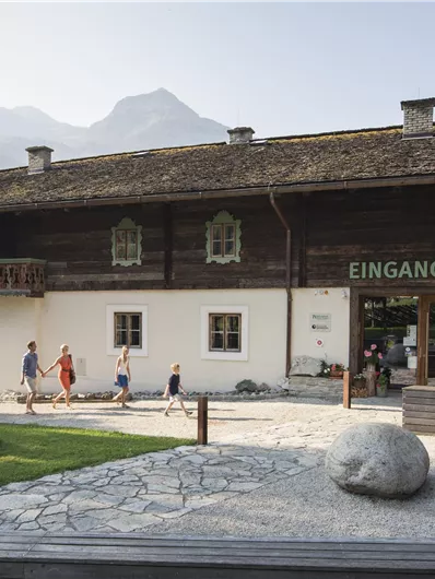 Ein traditionelles Gebäude mit der Beschriftung "EINGANG MUSEUM". Es sind Besucher zu sehen, die den Eingangsbereich betreten.