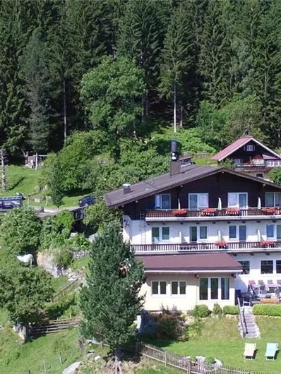 An idyllic estate amidst green meadows and dense forests. The buildings are designed in a traditional style and offer a tranquil atmosphere.