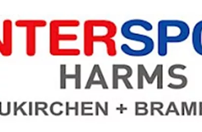 Ein Mann fährt auf einem Mountainbike durch eine hügelige Landschaft. Im Hintergrund sind grüne Berge und blauer Himmel zu sehen.