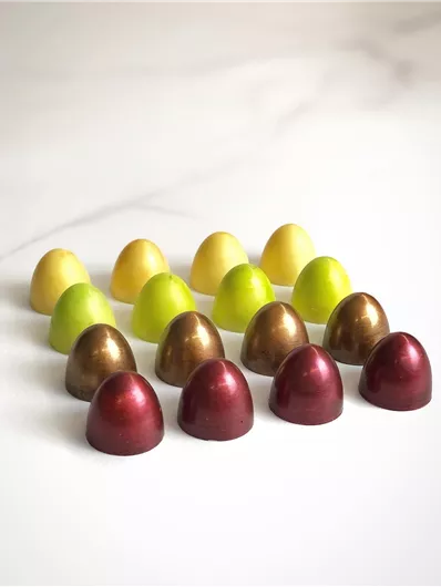 Kleurige chocolade-eieren gerangschikt in een aantrekkelijk patroon. De eieren zijn in verschillende kleuren zoals geel, groen, goud en rood ontworpen.