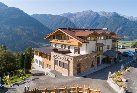 Ein gemütliches Restaurant in den Bergen mit malerischer Aussicht. Die Umgebung ist grün und die Berglandschaft ist beeindruckend.