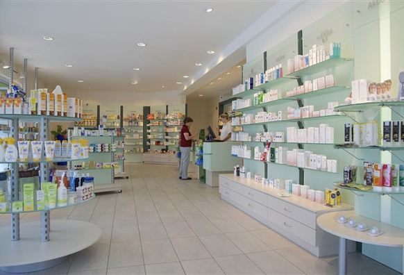Ein moderner Verkaufsraum mit Regalen voller Kosmetik- und Pflegeprodukte. Kunden stehen an der Theke und beraten sich.