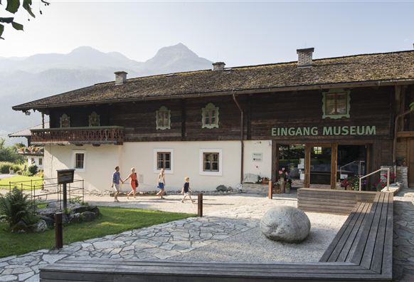 A traditional building with the inscription "ENTRANCE MUSEUM". There are visitors seen entering the entrance area.