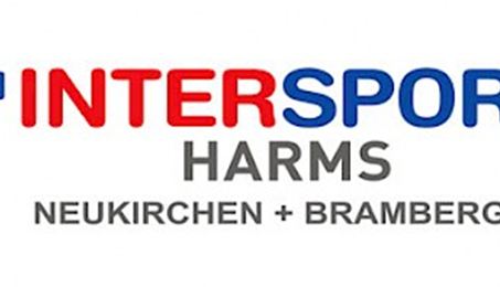 A man is riding a mountain bike through a hilly landscape. In the background, green mountains and a blue sky can be seen.