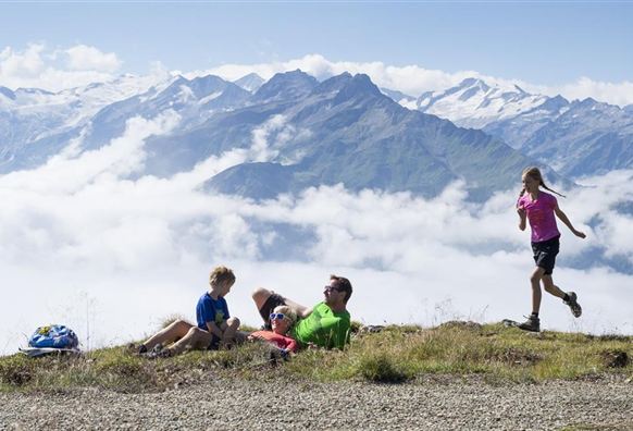Een gezin geniet van het uitzicht op de bergen. Kinderen spelen en ontspannen zich in de natuur.