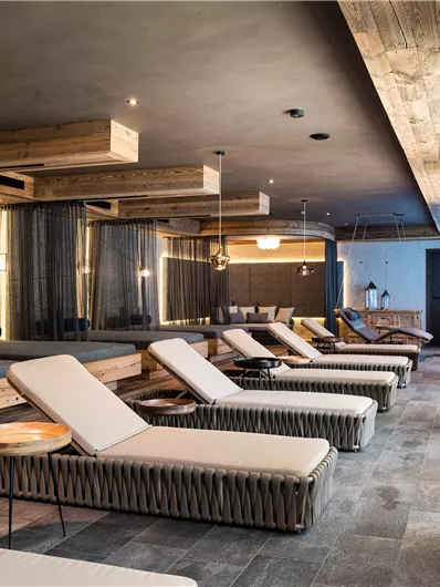 Een stijlvolle wellnessruimte met comfortabele ligstoelen en warme houten accenten. De ruimte straalt rust en ontspanning uit.