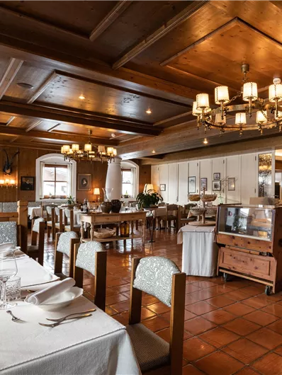 Ein stilvolles Restaurant mit Holzbalkendecke und elegante Tische. Das Ambiente ist gemütlich und einladend.