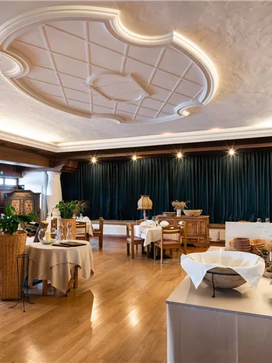Ein eleganter Restaurantbereich mit Holzfußboden und geschmackvoller Einrichtung. Sanfte Beleuchtung und gemütliche Tische schaffen eine einladende Atmosphäre.