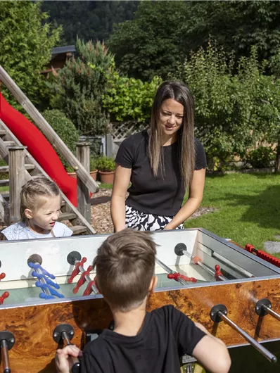 Een vrolijk gezelschapsspel in de tuin met een tafelvoetbalspel. Kinderen en volwassenen genieten van de tijd buiten.