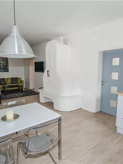 Eine helle Wohnung mit moderner Küche und gemütlichem Wohnbereich. Der Raum ist schlicht eingerichtet und lädt zum Verweilen ein.
