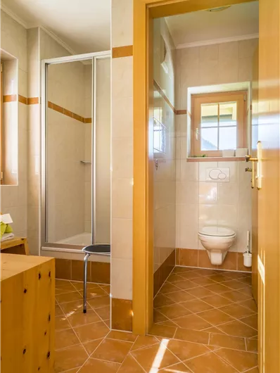 Een moderne badkamer met douche en toilet. Het is goed verlicht en biedt een vriendelijke sfeer.