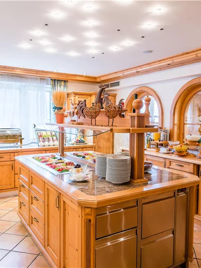 Ein einladender Frühstücksraum mit Holzregalen und einer Buffetstation. Frische Lebensmittel und Geschirr sind ordentlich arrangiert.