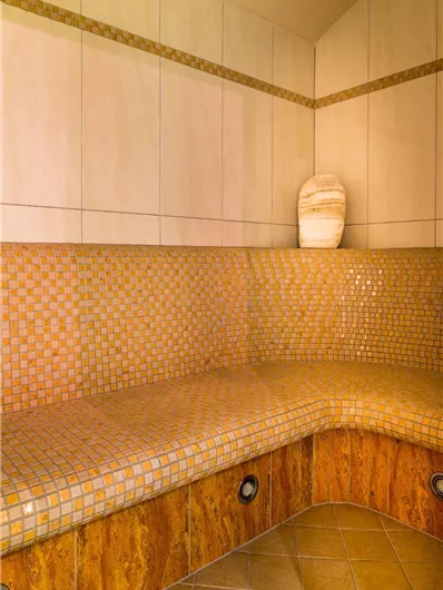 Een ontspannend stoombadgebied met heldere mozaïektegels. De muren zijn eenvoudig gehouden, ideaal voor ontspanning en wellness.