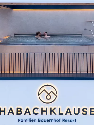 Ein Paar entspannt im Whirlpools im Habachklause Resort. Die moderne Umgebung vermittelt ein gemütliches Urlaubsgefühl.
