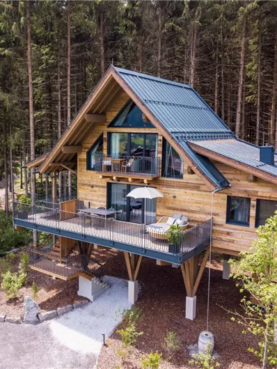 Een modern houten huis in een bosrijk gebied. Het terras biedt een mooi uitzicht op de omgeving.