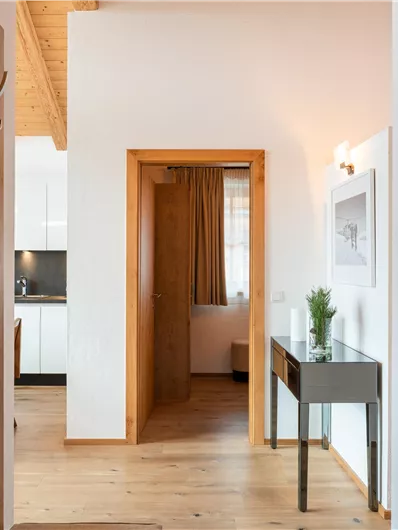 Ein helles und modernes Interieur mit Holzdetails. Der Eingangsbereich führt zu einem komfortablen Raum.