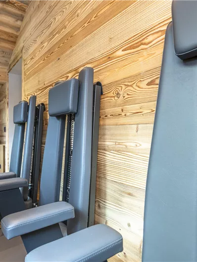 Een moderne ontspanningsruimte met meerdere speciale stoelen. De ruimte heeft houten wanden en een sfeervolle atmosfeer.