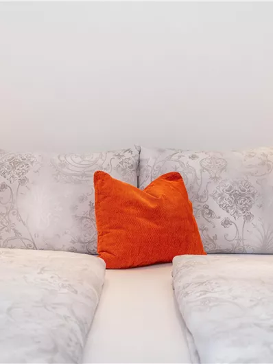 Een gezellige slaapkamer met een tweepersoonsbed en decoratieve kussens. Twee nachtlampjes zorgen voor een aangename sfeer.