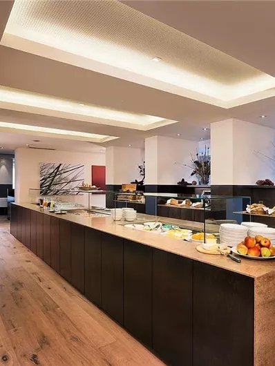 Een modern buffet in een elegant restaurant. De ruimte is helder verlicht en biedt een verscheidenheid aan gerechten op een lange tafel.