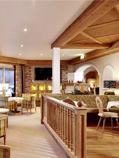 Een gezellig restaurant met houten decor en grote ramen. De zitplaatsen zijn comfortabel en uitnodigend.