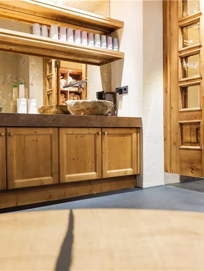 Eine gemütliche Innenraumansicht mit einem Holzschrank und einem Spiegel. Der Raum hat warmes Licht und eine einladende Atmosphäre.