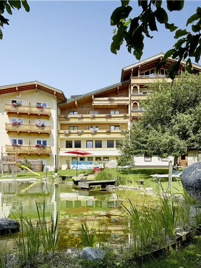 Een charmant hotel omringd door groen en een klein vijver. De rustige sfeer nodigt uit tot ontspanning.