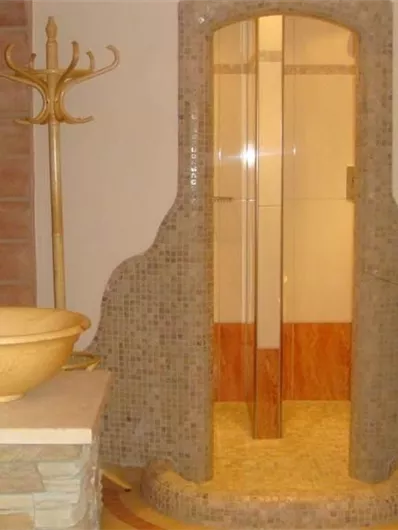 Een modern badkamer met een glazen douche en een stijlvolle houten wastafel. De inrichting oogt elegant en uitnodigend.