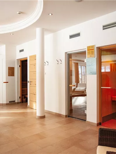 A bright and inviting interior with wooden shelves and several doors. The room feels modern and friendly, perfect for relaxation.