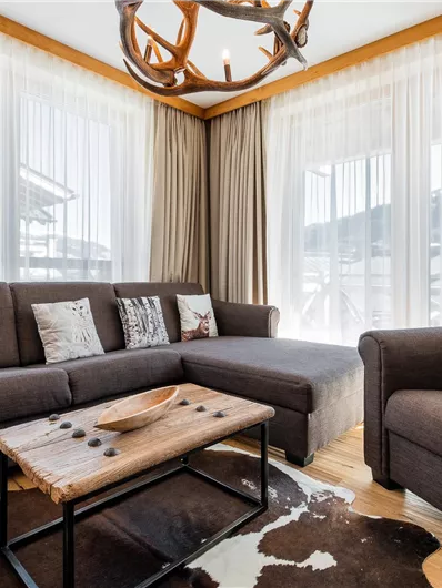 A cozy living room with a gray sofa and a comfortable armchair.
Large windows let in plenty of daylight and provide a view of the outside landscape.
