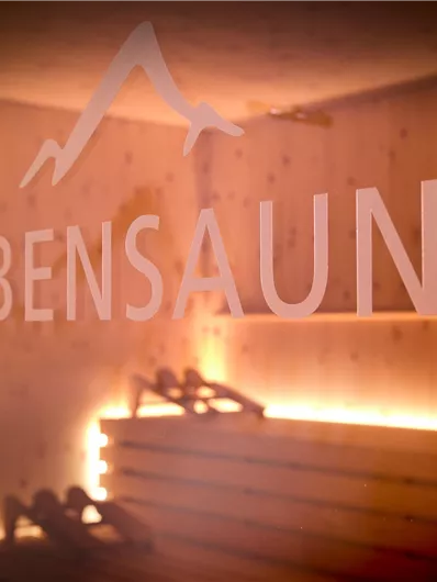 Een ontspannende ruimte met een cederhouten sauna. Zachte verlichting en houten elementen creëren een rustgevende sfeer.