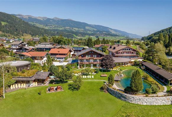 Wanderhotel Kirchner mit großer Gartenanalge, Liegeweise und hoteleigenem Badesee.